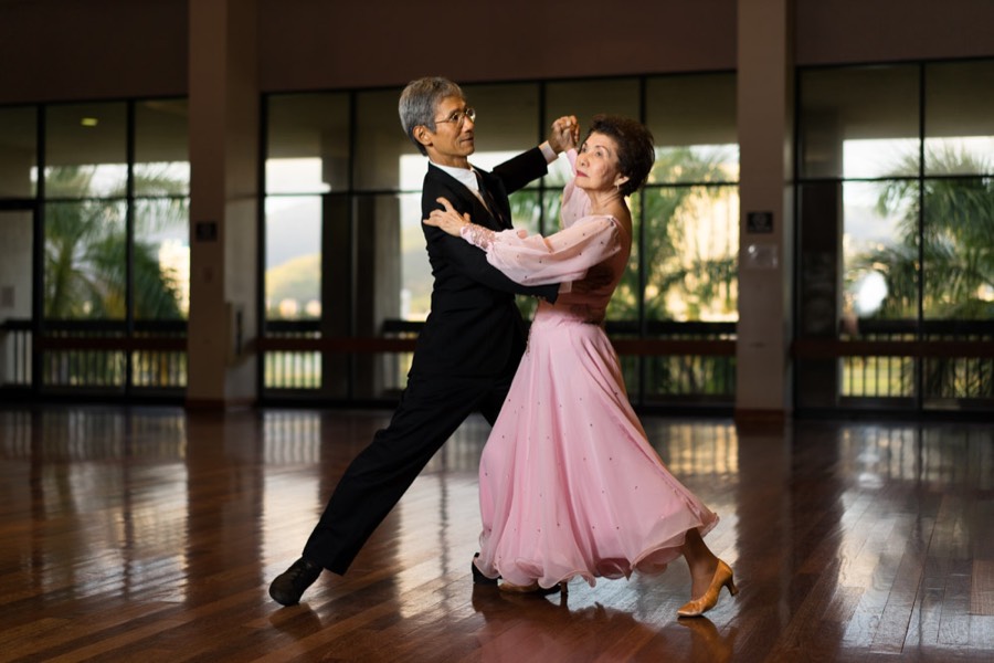 A couple in a pink gown and dark suit dancing a smooth waltz